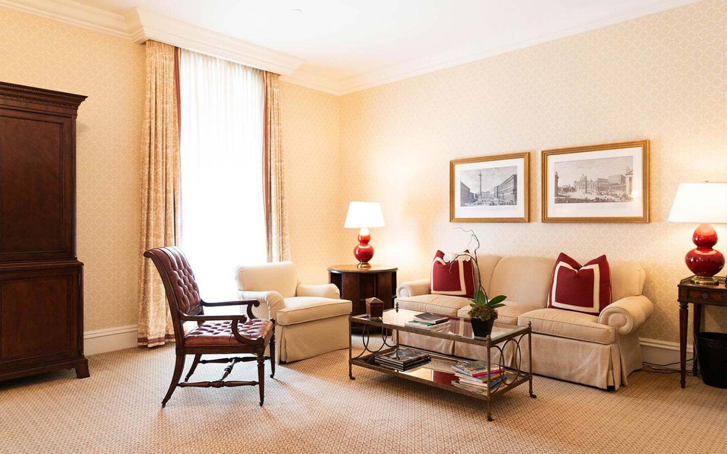 couch and table area in a guest room next to a large window and wooden dresser
